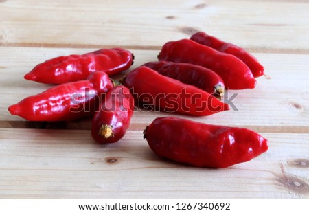 Group of ripened Bhut jolokia red, very hot peppers on wooden table, Picture design for foods background.
