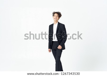 Curly handsome man in a dark suit on a light background             