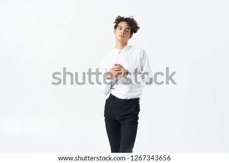 Curly business man in a white shirt holds his hands together                  