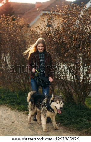 Blonde lady model poses to photographer with husky dog