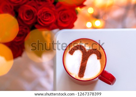 a cup of cappuccino coffee with a zodiac sign pattern of cinnamon aries on milk froth