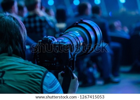 Journalist photographer with a telephoto lens at work, back view Royalty-Free Stock Photo #1267415053
