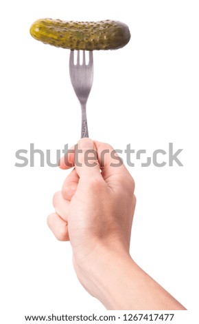 salted cucumber on a fork held by a hand isolated on white background. Clipping Path. Full depth of field.

