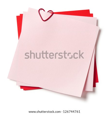 pink and red sticky notes with paper clip in shape of heart on white background