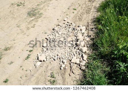 Pits on the road are filled with stones. Quarry stone