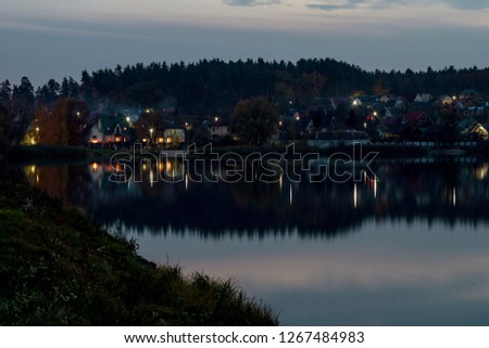 Village on the lake. Evening landscape with a reflection in the water. Selective focus. 
