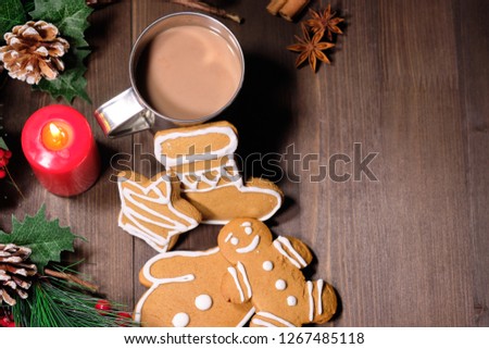 Christmas gingerbread  and coffee with milk in the iron cup on brown background with Christmas tree . Close up