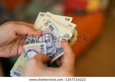 Details with the hands of a young lady counting banknotes of 50 and 100 Romanian Lei currency Royalty-Free Stock Photo #1267516222