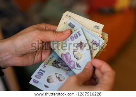 Details with the hands of a young lady counting banknotes of 50 and 100 Romanian Lei currency Royalty-Free Stock Photo #1267516228