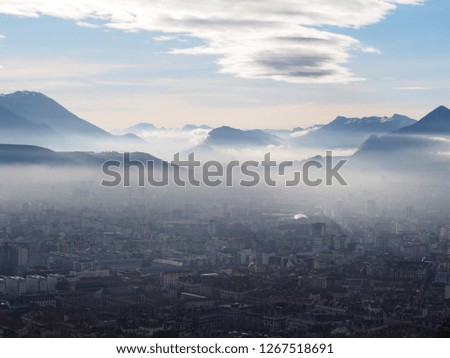 Photography that is showing a sea of clouds above the city of Grenoble, France