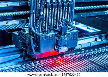 Close-up surface-mounting machine in progress. SMT (surface-mount technology) is a method for producing electronic circuits. Components are placed directly onto the surface of printed circuit boards. Royalty-Free Stock Photo #1267522492