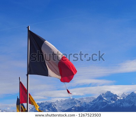Photography that is showing a French flag fluttering in the wing