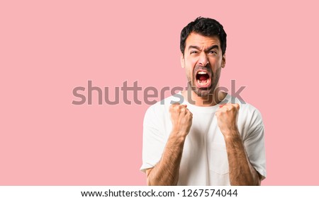 Young man with white shirt annoyed angry in furious gesture. Frustrated by a bad situation on isolated pink background Royalty-Free Stock Photo #1267574044