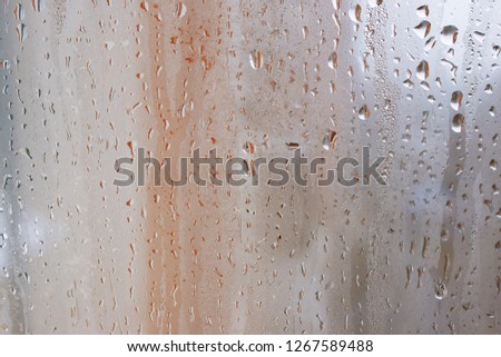Natural water drop background, window glass with condensation humidity, large droplets flow down. Collecting and streaming down 