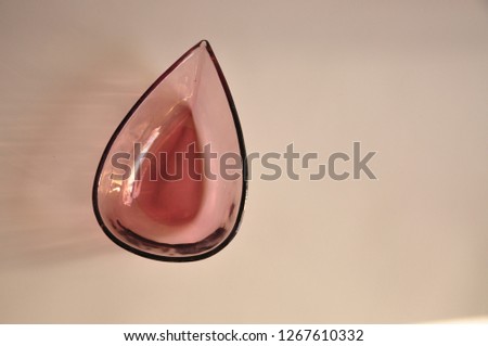 Empty glass tear-shaped bowl on a white background