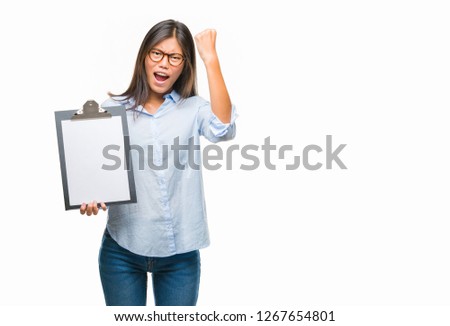 Young asian business woman over isolated background holding clipboard annoyed and frustrated shouting with anger, crazy and yelling with raised hand, anger concept