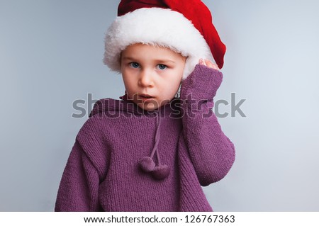 girl in a Christmas hat, adjusts his cap hand, black background