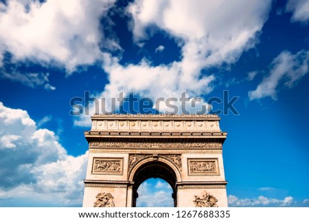 A photo of the Arc de Triomphe with a blue sky in the background,