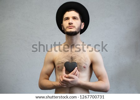 Young man with black heart in hands.