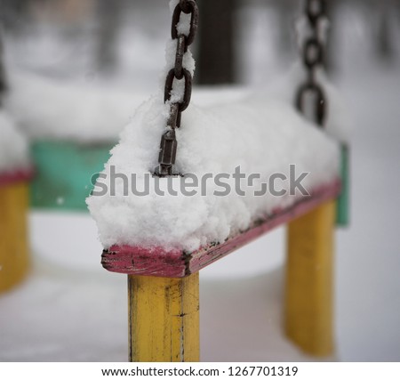 bench in the snow on the playground 