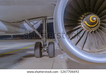 Close-up view on Airbus A320-232 aircraft's IAE V2500 engine, fuselage and left main landing gear at night. Tbilisi International Airport, Tbilisi, Georgia Royalty-Free Stock Photo #1267706692