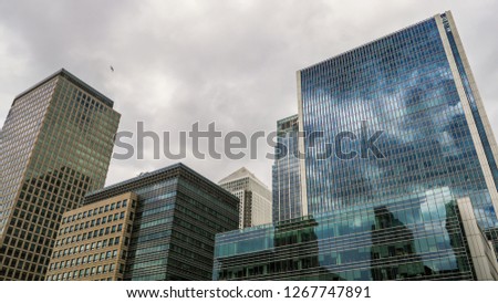 View of a group of buildings and reflections with sky and clouds in Canary Wharf in London, Europe