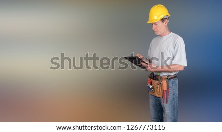 Building worker with tool belt taking notes on blurred background