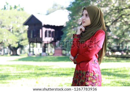 Cute young women wearing hijab and red top. Malay traditional concept picture. Elegant face.