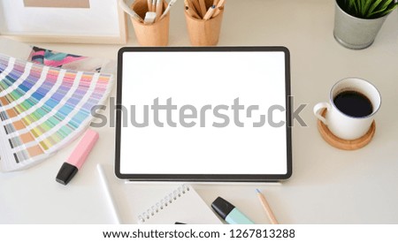 Blank screen tablet on desktop in graphic design studio