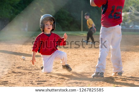 Young Baseball Player Sliding into Home Plate Royalty-Free Stock Photo #1267825585