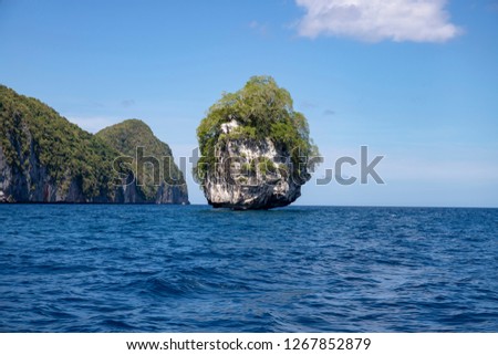 Small tropical island and sea landscape. Marine travel in tropical seashore. Weathered rock with tree. Natural landscape with mountain and sea. Palawan island boat trip. Philippines vacation travel.