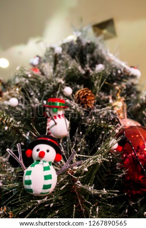  Doll snowman hang on a charismas tree with blurry background in the winter season.