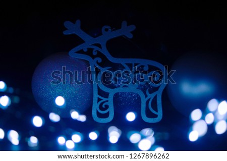 Reindeer and Christmass baubles with blue glows from garland in the bottom