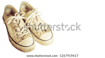 Low-top ladies off-white canvas athletic shoes on a white background
