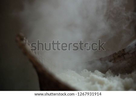 White smoke from glutinous rice steaming in countryside kitchen. selective focus.
