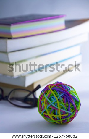 Books, glasses and colorful rubber band on white background.