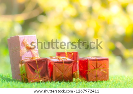 Gift box on green grass background with as a present for Christmas, new year, valentine day or anniversary.