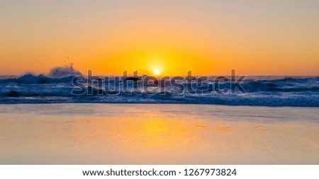 sunset on a sandy beach Photographed on a West coast facing beach in Cape Town South Africa.