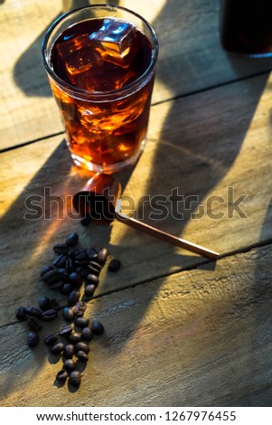 Setup ice coffee americano in a glass on wood table with sugar, milk. - Image