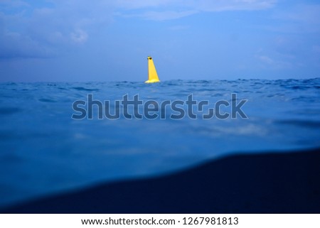 A yellow buoy in the sea, yellow buoy steel navigational floating buoy in the blue sea water, Safe swimming buoy,