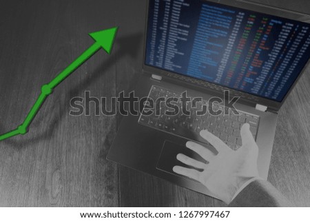 Laptop with hand showing rising stock market value price.