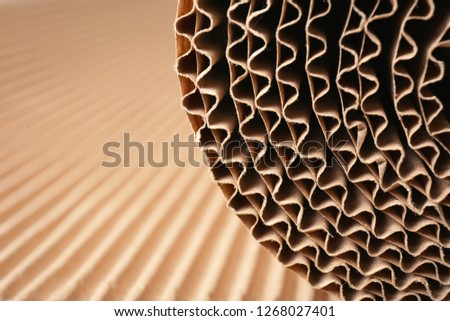 Closeup view of roll of brown corrugated cardboard, space for text. Recyclable material Royalty-Free Stock Photo #1268027401