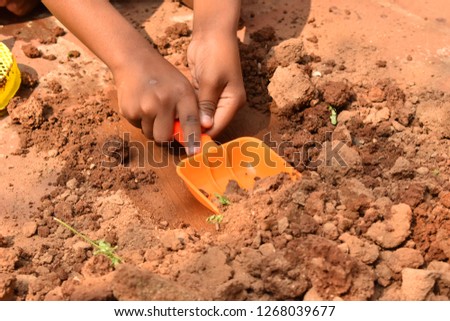 Indian Kids playing with the gardening tools with mud clay and water  Royalty-Free Stock Photo #1268039677