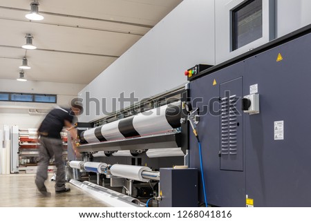 Computer aided printing process, advanced technology in the press and publishing sector, latest generation robotized plotting machines for mass production and big format prints. Royalty-Free Stock Photo #1268041816