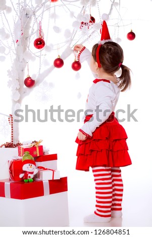 girl hangs a Christmas toy
