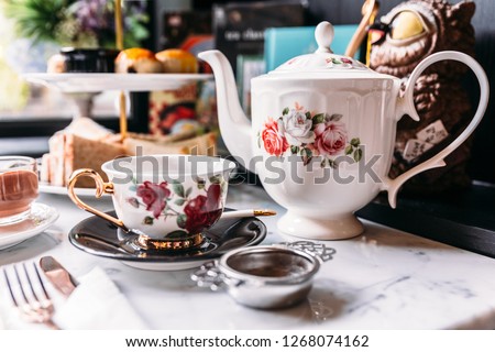 English Vintage Porcelain Roses Tea Sets including teapot, tea cup, plate, spoon and tea filter. Royalty-Free Stock Photo #1268074162