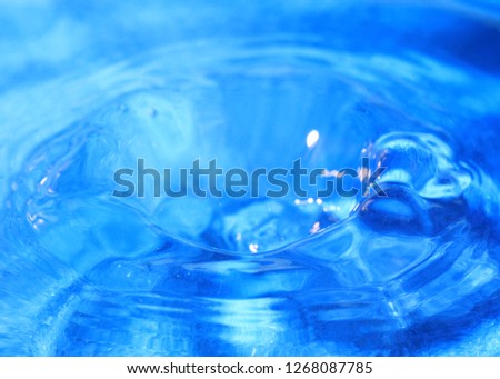 a drop of pure water creates fantasy patterns when striking the surface of a liquid