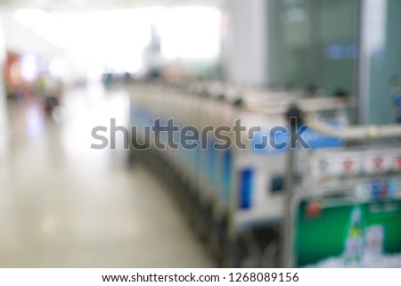 Blurred defocused image of airport luggage cart, trolleys luggage in airport or market, mall, supermarket. Royalty high-quality stock blurry photo image of airport luggage cart with empty copy space
