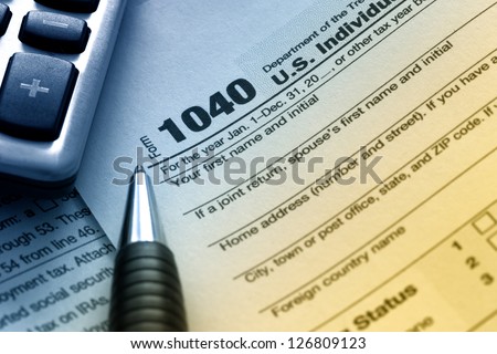 US tax form 1040 with pen and calculator. Royalty-Free Stock Photo #126809123