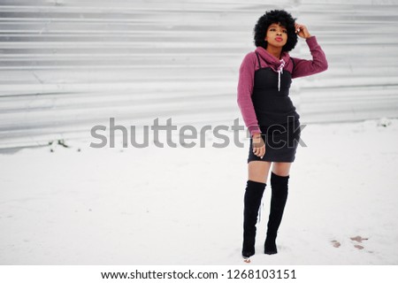 Curly hair african american woman posed at winter day. Afro model girl against snow.
